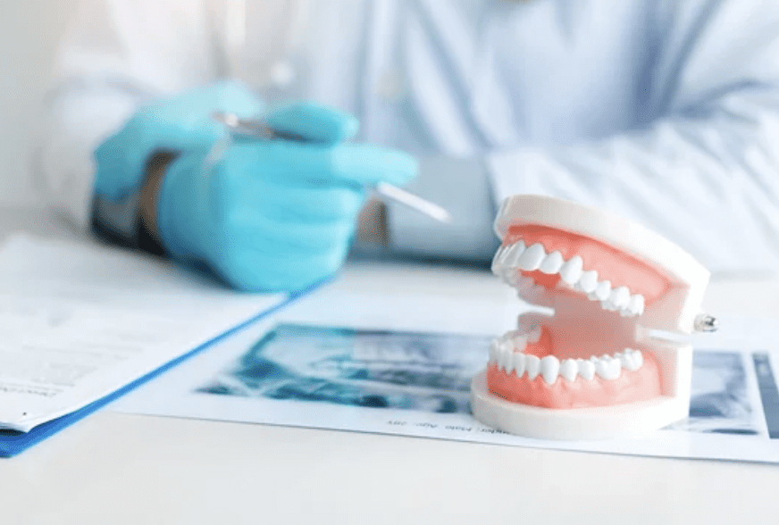 Dentist giving a consultation with dentures sitting on the desk dentist in Amherst New York 